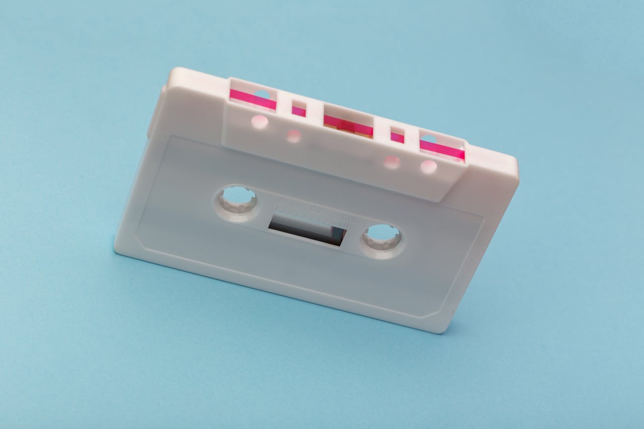 Vintage white cassette tape against a vibrant blue backdrop, capturing classic audio technology nostalgia.